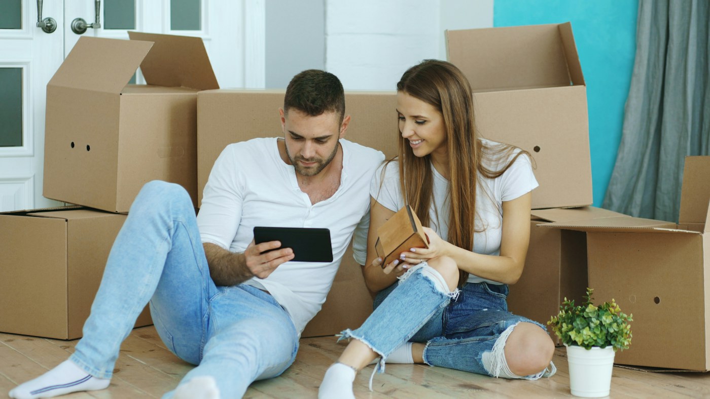 A couple settling into a home surrounded by moving boxes
